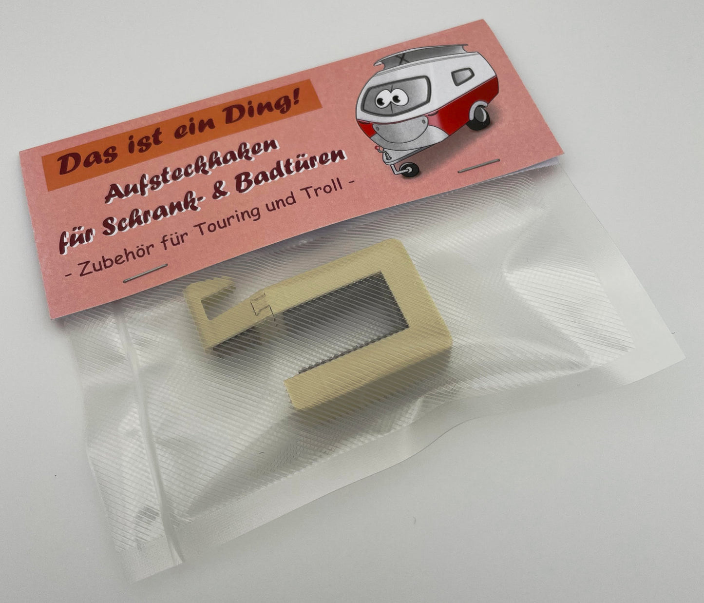 Produktverpackung eines Aufsteckhakens für Schrank- und Badtüren im Eriba Touring, Troll oder Puck. Zu sehen ist die Vorderseite des Produktes.