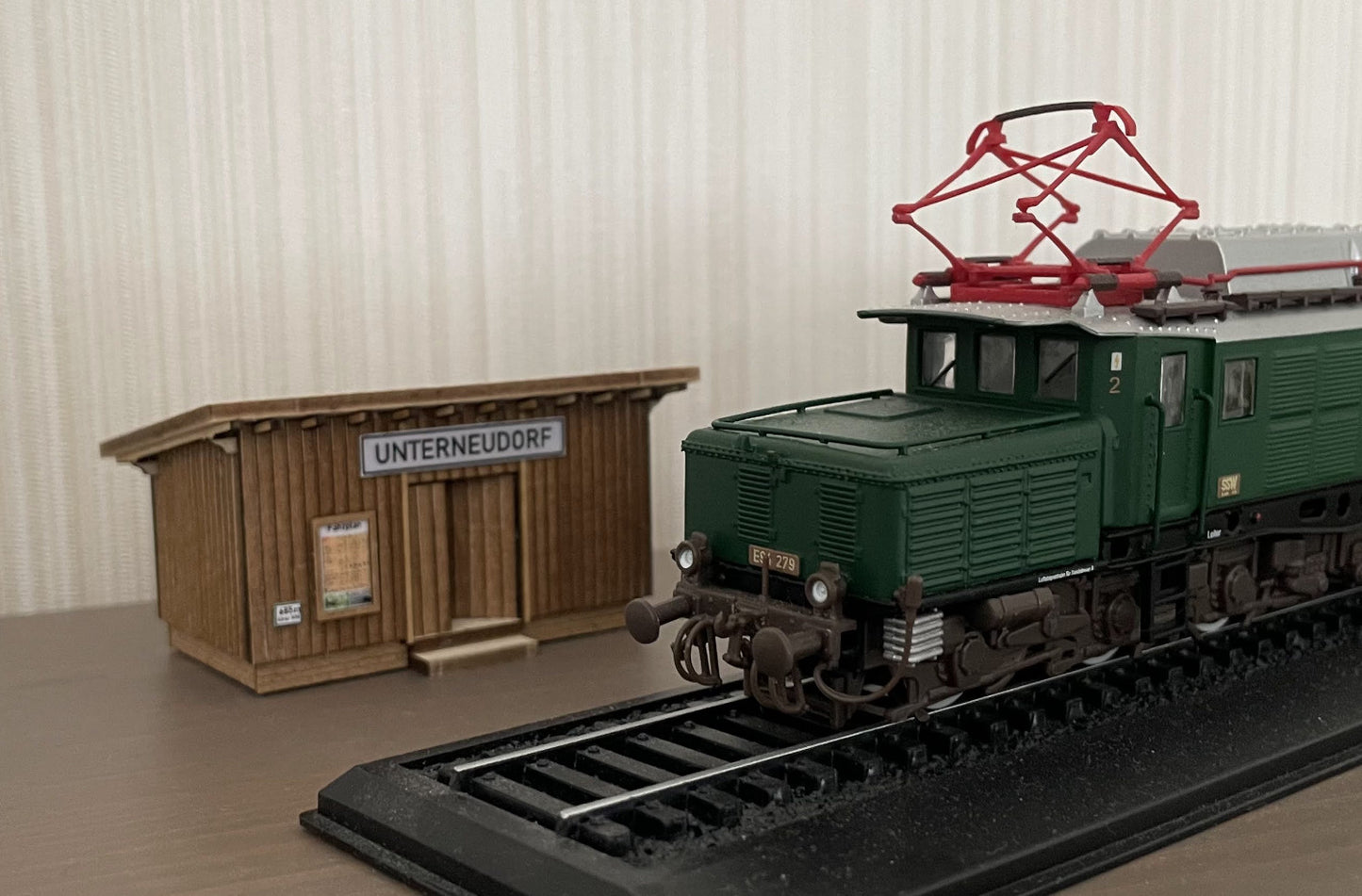 Größenvergleich des Wartehauses Haltepunkt "Unterneudorf" in Spur H0 im Verhältnis zu einer E-Lok BR94, ebenfalls in Spur H0.