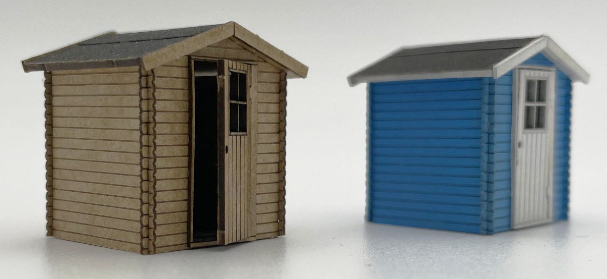 Ein zweites Beispielbild zum Vergleich der Kleinen Gartenhütte H0 - 1/87: links unlackiert, rechts blau mit weißen Akzentuierungen.
