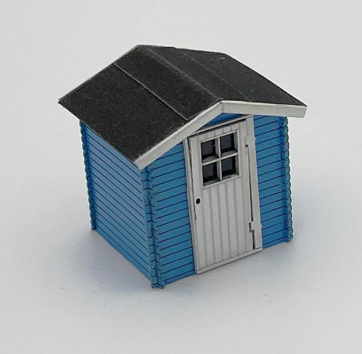 Kleine Gartenhütte H0 - 1/87, hier in blau mit weißen Akzentuierungen. Dargestellt ist das Modell von vorne, Blickrichtung von inks oben.